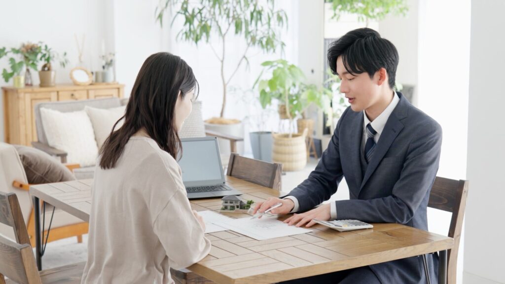 家にかかる費用について解説する住宅会社スタッフと顧客