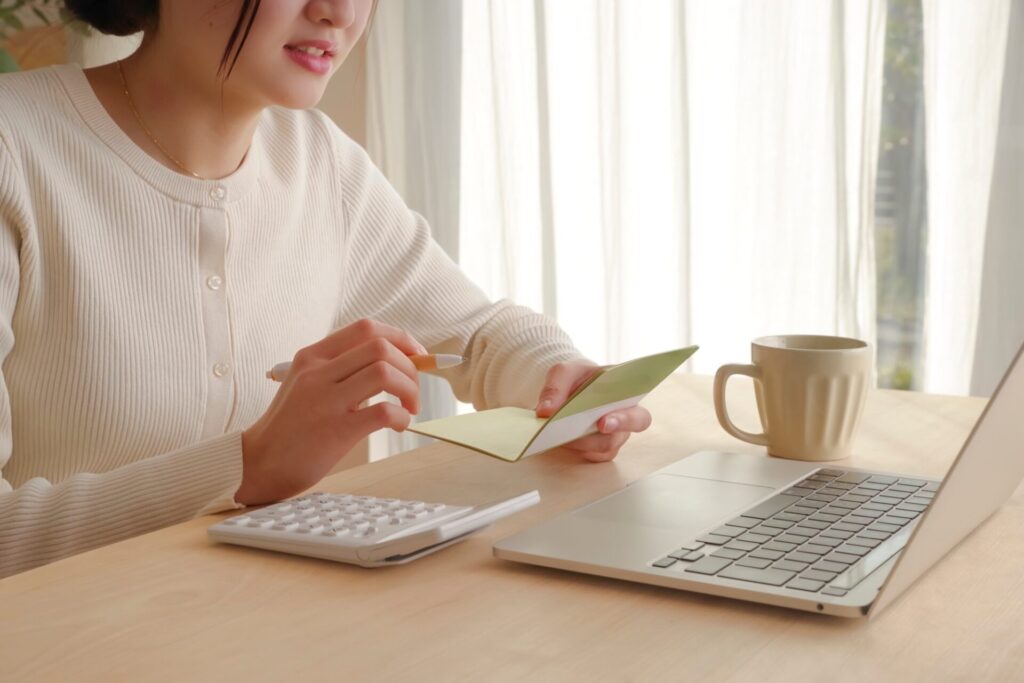 通帳をみて家づくりの資金計画を立てる女性
